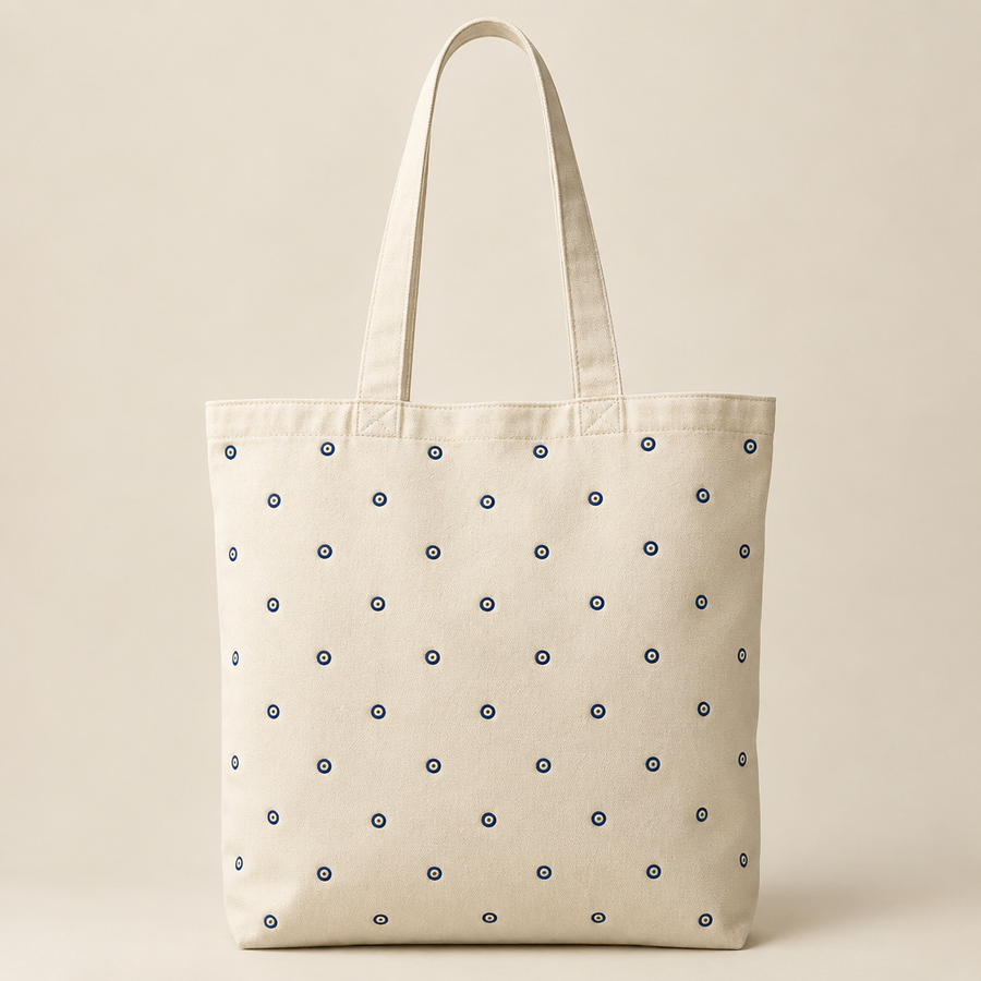 Ivory tote with tiny Evil Eyes dotted across the front